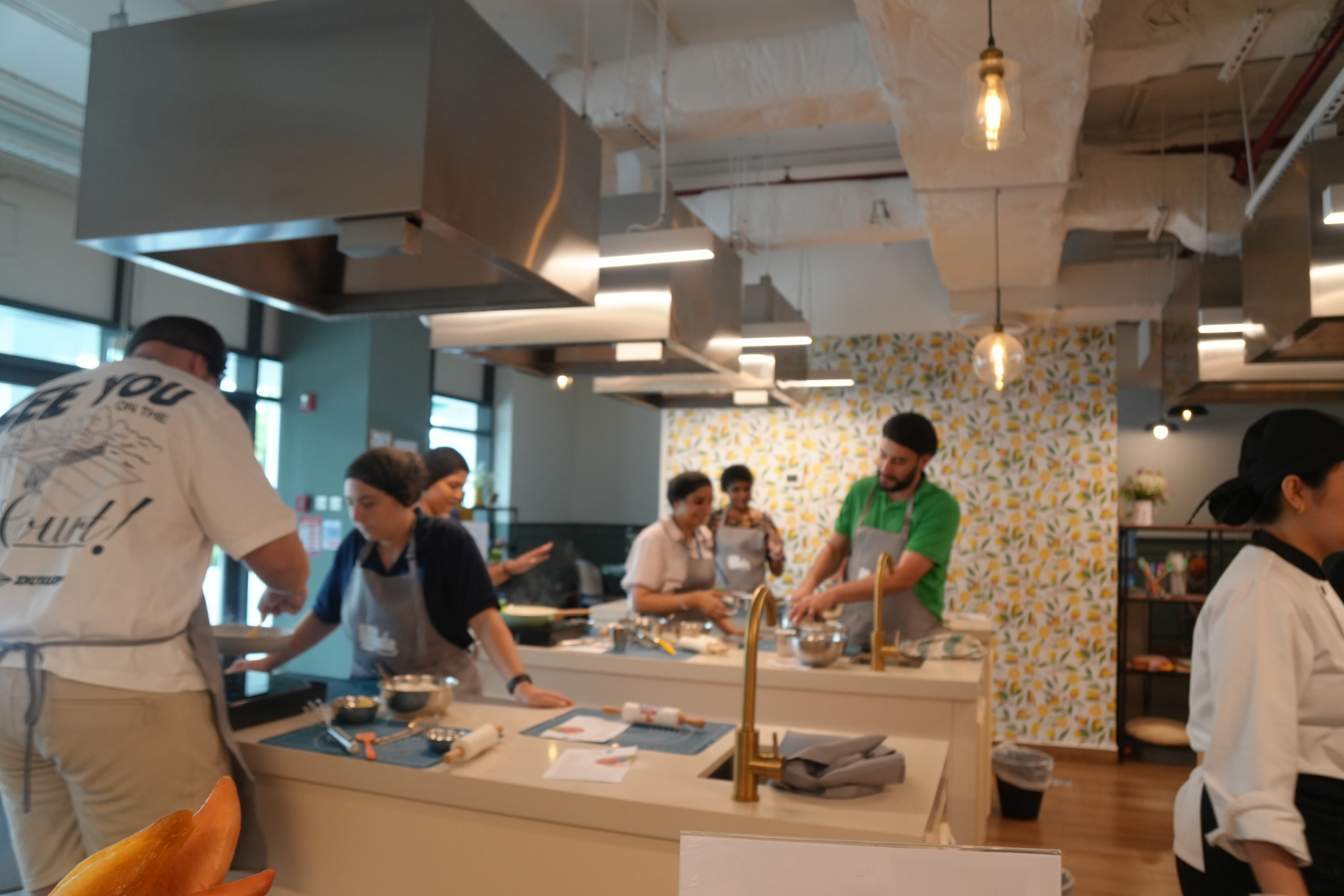 Participants working in pairs at the institute's cooking stations during a corporate workshop